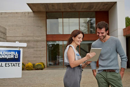 An agent and a customer is discussing in front of a property